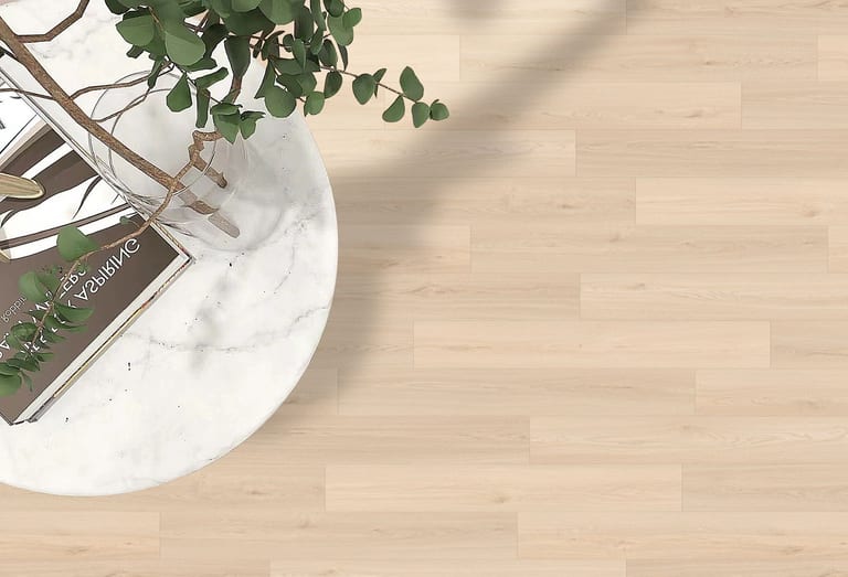 Light maple laminate floor beneath a marble side table and eucalyptus