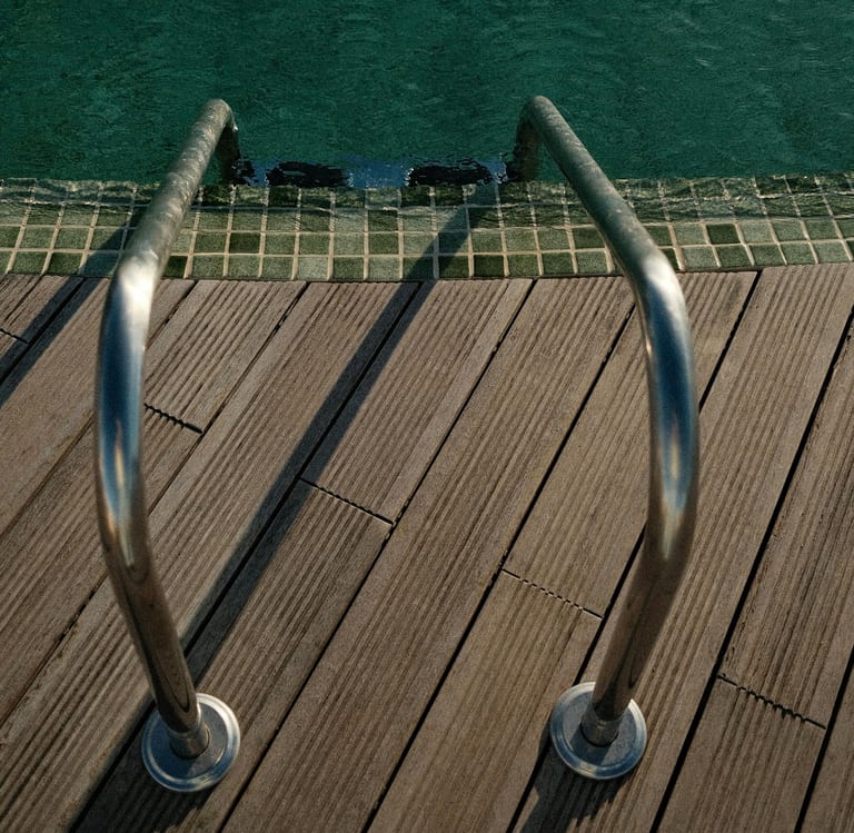 Grooved composite deck boards meeting a tiled pool edge